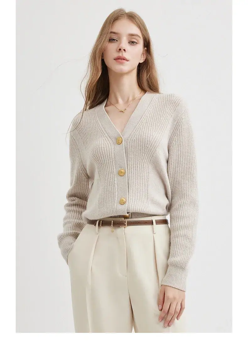 Elegant beige knitted cardigan for women, featuring gold buttons, styled with high-waisted trousers for a sophisticated look.